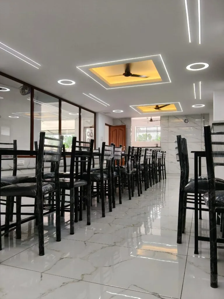 A vibrant and well-decorated dining-cum-mini-party hall at a ladies' hostel in Kakkanad, Kochi, designed for resident celebrations and social gatherings.